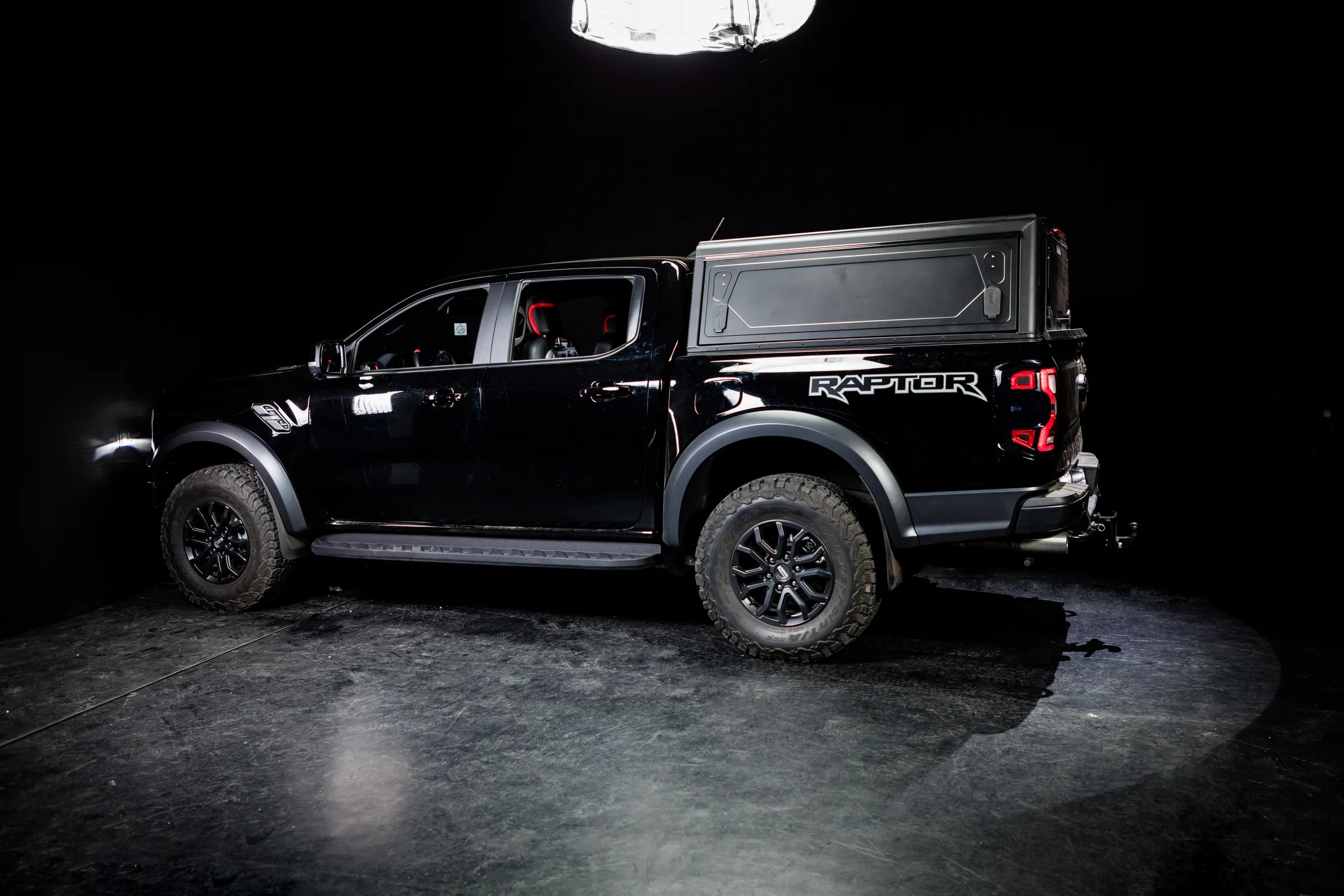 Fekete Ford Ranger Raptor overland pickup-felépítménnyel stúdióban
